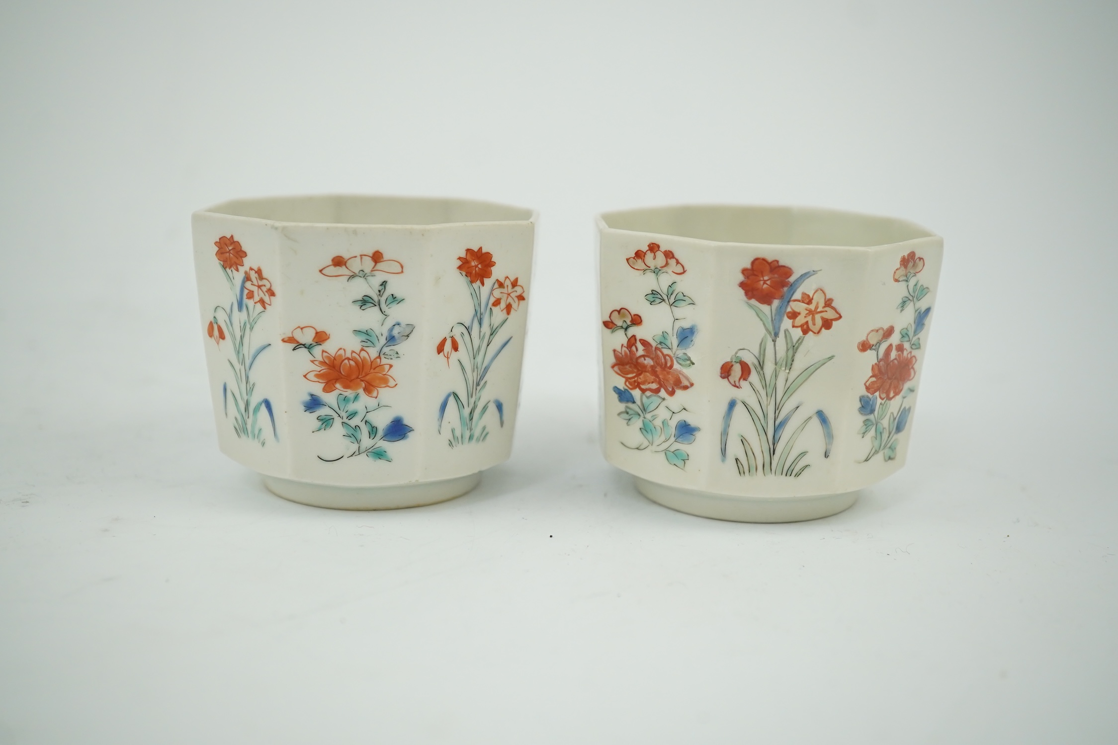 A pair of Japanese kakiemon octagonal porcelain cups, probably Edo period, 5.5cm high. Condition - one restored the other hairline cracks